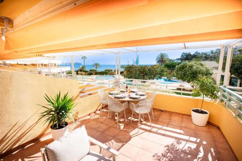a balcony with a table and chairs and a pool at Voramar III by the beach large terrace in Calpe