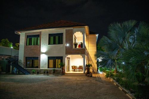 a house at night with a palm tree at Rebero A3s apartment in Kigali