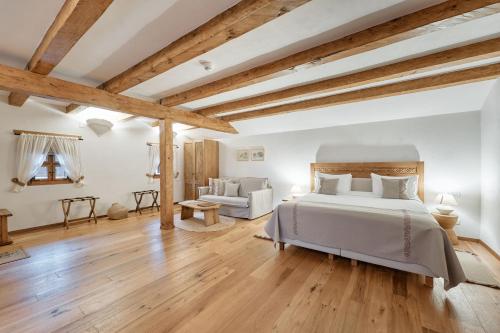 a bedroom with a white bed and wooden beams at Matca Hotel Relais & Châteaux in Şimon