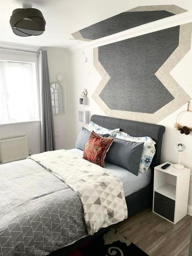 a bedroom with a bed and a geometric wall at The Grand Forsyth Apartment - Two bedroom in Dagenham