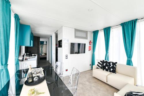 a living room with blue curtains and a couch at San Benedetto Camping Relais in Peschiera del Garda
