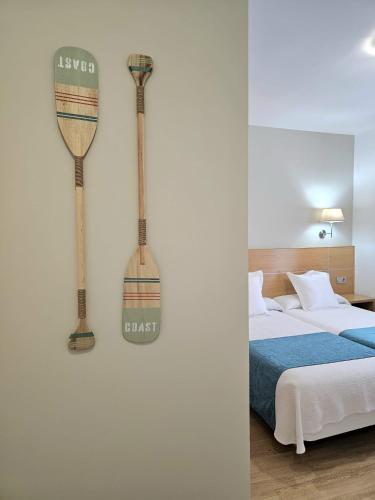 a bedroom with a bed and two axes on the wall at Musika Plaza in Zarautz
