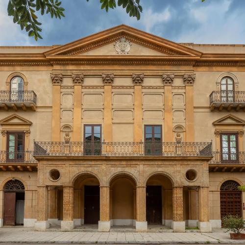 an old building with a balcony on top of it at Palazzo De Gregorio - Apartments in Palermo