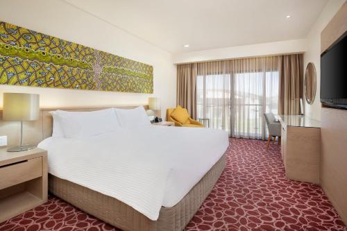 a hotel room with a large bed and a desk at Crowne Plaza Alice Springs Lasseters by IHG in Alice Springs