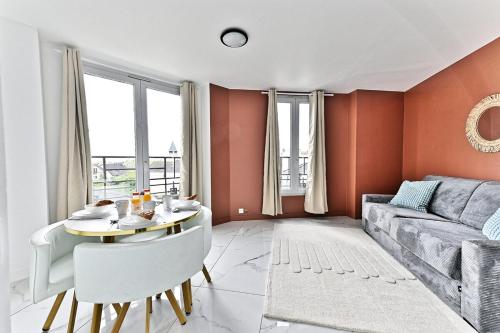 un salon avec une table et un canapé dans l'établissement Modern and spacious 2 bedroom apartment - III, à Gagny
