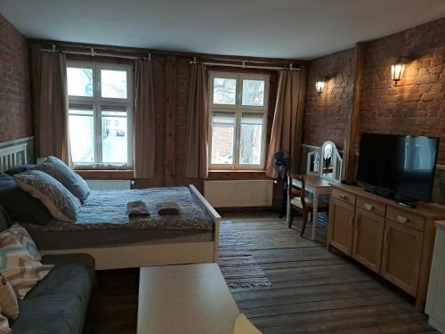 Una sala de estar con un sofá y un televisor de pantalla plana. en Stare Miasto Widok na Katedrę, en Olsztyn
