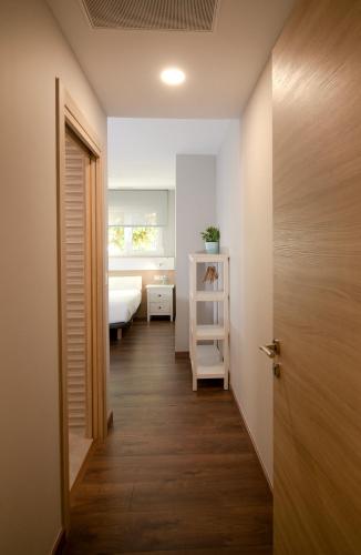 a hallway with a room with a bed and a door at Pensión Boutique ADMERA in Santiago de Compostela