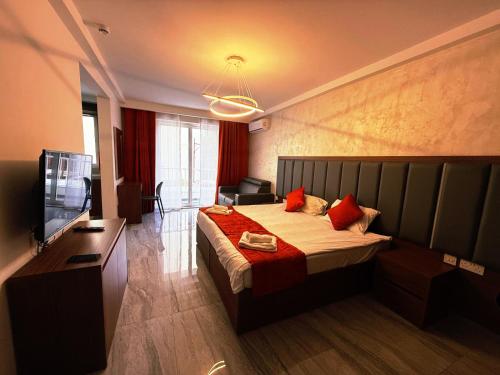 a hotel room with a bed and a television at The Urban Suites in Il-Gżira