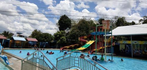 a group of people in a swimming pool at Arraudah Hotel Syari'ah in Paringin