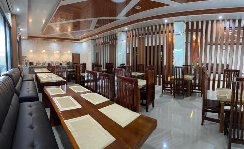 a dining room with tables and chairs in a restaurant at Arraudah Hotel Syari'ah in Paringin