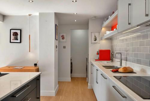a kitchen with white cabinets and a counter top at Finest Retreats -Little Granary in Salcombe