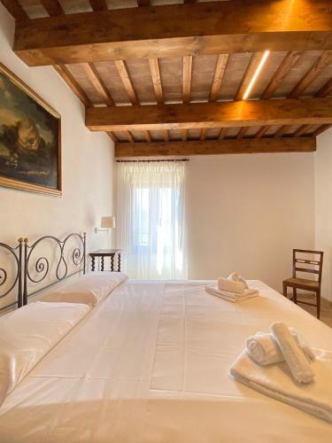 a bedroom with a large white bed with two towels on it at Agriturismo Pieve San Biagio - Adults Only in Macerata