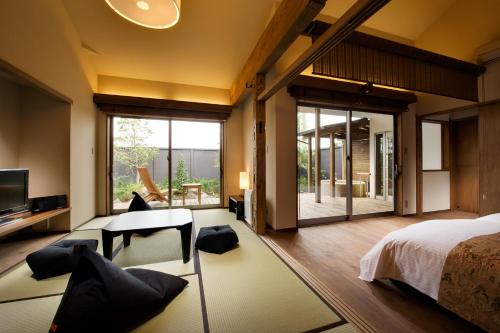 um quarto com uma cama, uma mesa e cadeiras em Migiwaya em Yaizu