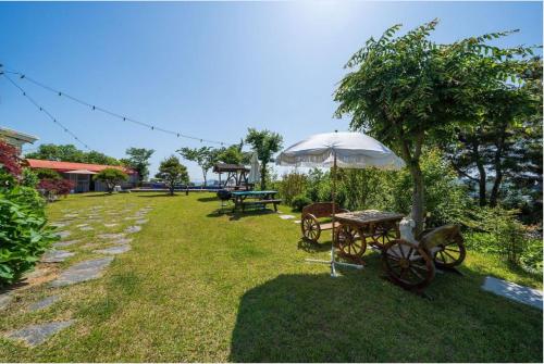a picnic table and an umbrella in a yard at Nobless Pension in Taean