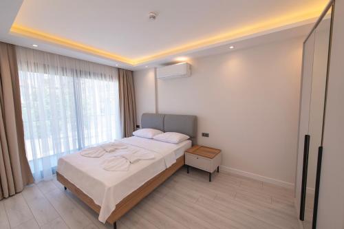 a bedroom with a bed and a large window at Calis Suites Çeşme - Only Family in Cesme