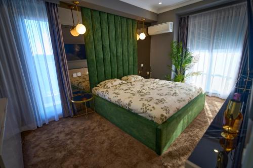 a bedroom with a bed with a green wall at Cozy Glow Loft in Bucharest