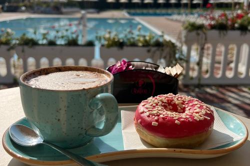 a cup of coffee and a donut on a table at San Benedetto Camping Relais in Peschiera del Garda