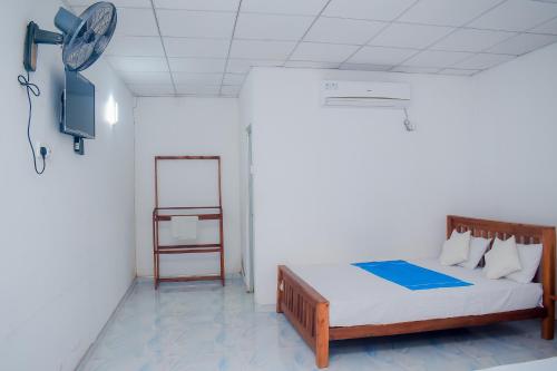a bedroom with a bed and a clock on the wall at Hotel Sanjana & Restaurant in Polonnaruwa