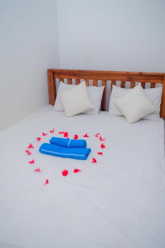a bed with red rose petals on it at Hotel Sanjana & Restaurant in Polonnaruwa