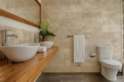 a bathroom with a sink and a toilet at Anusara Luxury Villas in Ubud