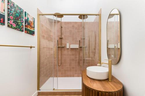 a bathroom with a shower with a sink and a mirror at Weekn'spa Tournus in Tournus