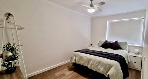 a bedroom with a bed and a ceiling fan at South Seas 5- Absolute Beachfront Wifi Views in Port Elliot