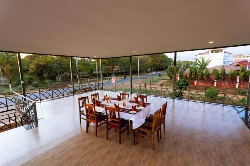a dining room with a table and chairs on a balcony at Keys Hotel in Moshi