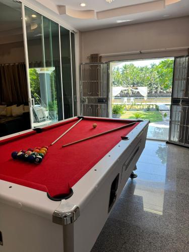 a pool table in a room with a red and white at ริมน้ำบ้านแม่ อัมพวา เหมาหลัง 5 นอน พักได้ 10 คน in Samut Songkhram