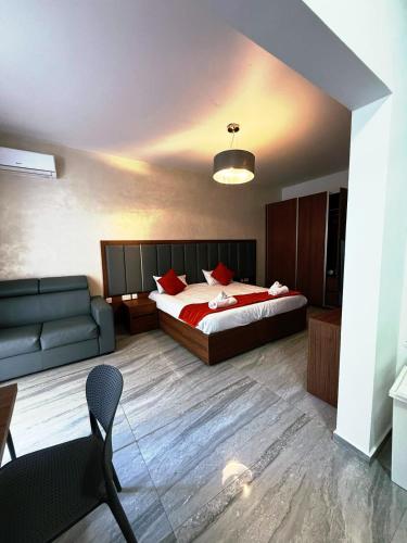 a bedroom with a bed and a couch at The Urban Suites in Il-Gżira