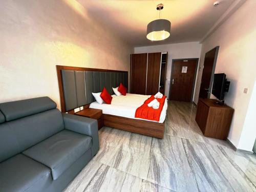 a bedroom with a bed and a couch in it at The Urban Suites in Il-Gżira