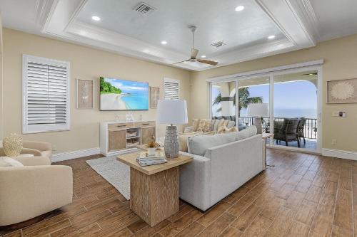 a living room with a couch and a table at Curious Tides Gulf-Front 10BR Estate- Private Pools, Spas, Views townhouse in Fort Myers Beach