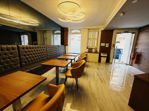 a restaurant with wooden tables and chairs in a room at The Urban Suites in Il-Gżira