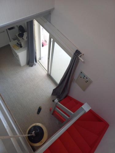 a room with a staircase with a red couch and a window at Villa patio Seignosse in Seignosse
