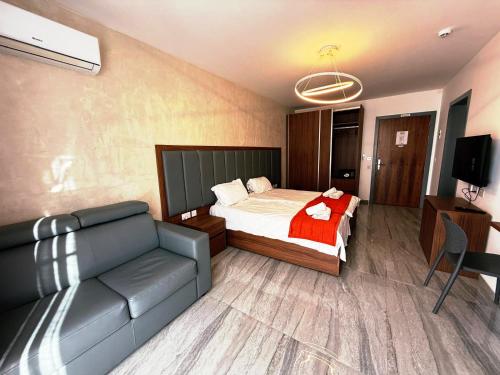 a bedroom with a bed and a couch and a television at The Urban Suites in Il-Gżira