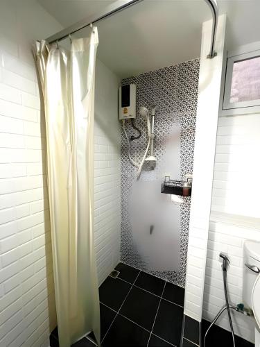 a bathroom with a shower with a shower curtain at Mitr Inn The Grand Palace Bangkok - Mrt Samyot Station Pro in Bangkok