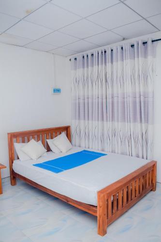 a bedroom with a large bed with a curtain at Hotel Sanjana & Restaurant in Polonnaruwa