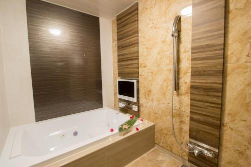a bathroom with a tub and a shower with a television at ホテル アンジュエトワール 堺 - Adult Only in Sakai