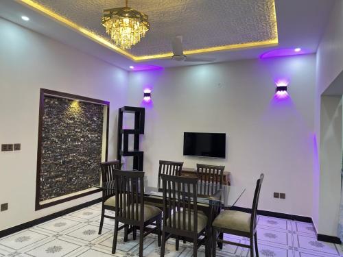 a dining room with a table and chairs and a tv at 2 BHK GF - Villa in Bahria Enclave, Islamabad in Islamabad
