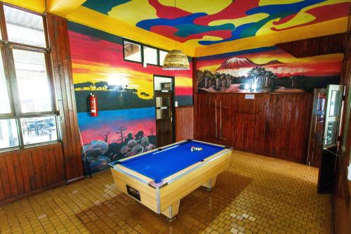 a pool table in a room with a mural at Keys Hotel in Moshi