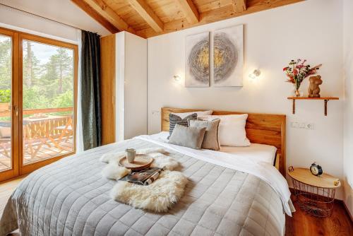 a bedroom with a large bed with a large window at Landhaus Trinis - Kleine Kaffee Tee Theke mit Kühlschrank - Parkplatz in Rottach-Egern