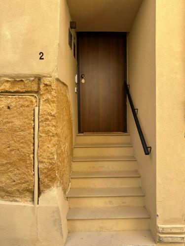 a set of stairs leading to a wooden door at Arc Home apartment in Agrigento