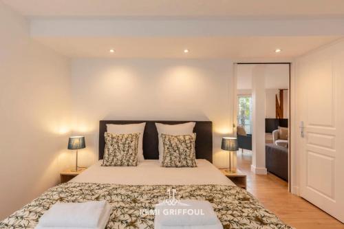 une chambre avec un grand lit avec deux lampes dans l'établissement The Duplex Varin Beautiful Apartment & Garden Honfleur 4 People, à Honfleur