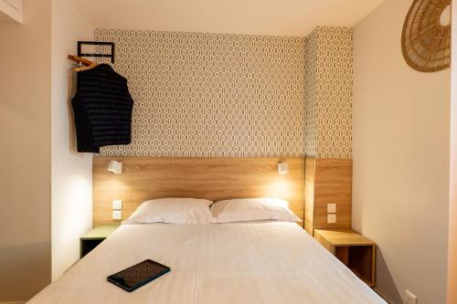 a bedroom with a bed with a wooden headboard at Hôtel Océan Dinan in Dinan