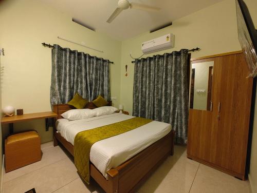 a bedroom with a bed and a window with curtains at Bethel in Cochin