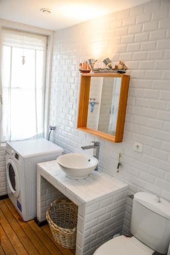 une salle de bain avec un lavabo et une machine à laver dans l'établissement La Maison Bleue, à Cabourg