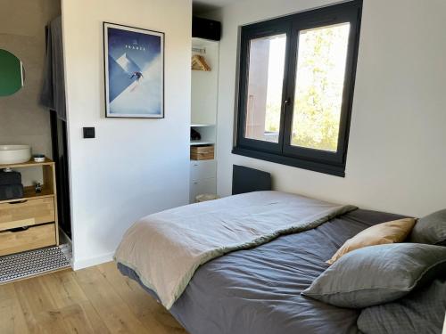 une chambre avec un lit et une fenêtre dans l'établissement Cocon alpin, à Cordon