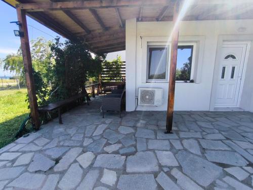 an outdoor patio with a bench and a window at Samothraki Vacation Home, amazing Saos view, 2BR in Samothráki