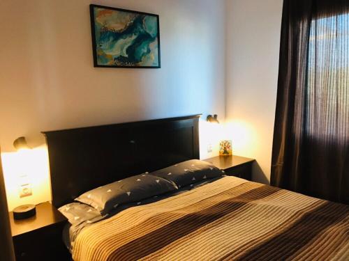 a bedroom with a bed and two lamps and a window at Samothraki Vacation Home, amazing Saos view, 2BR in Samothráki