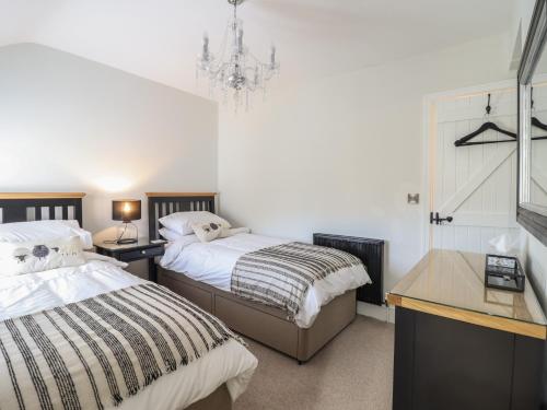 a bedroom with two beds and a chandelier at Glynside in Conwy