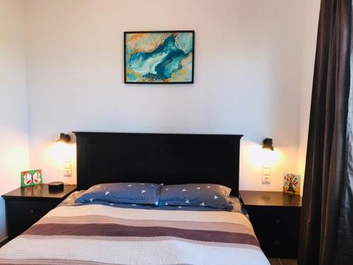 a bedroom with a bed with two lamps and a picture on the wall at Samothraki Vacation Home, amazing Saos view, 2BR in Samothráki